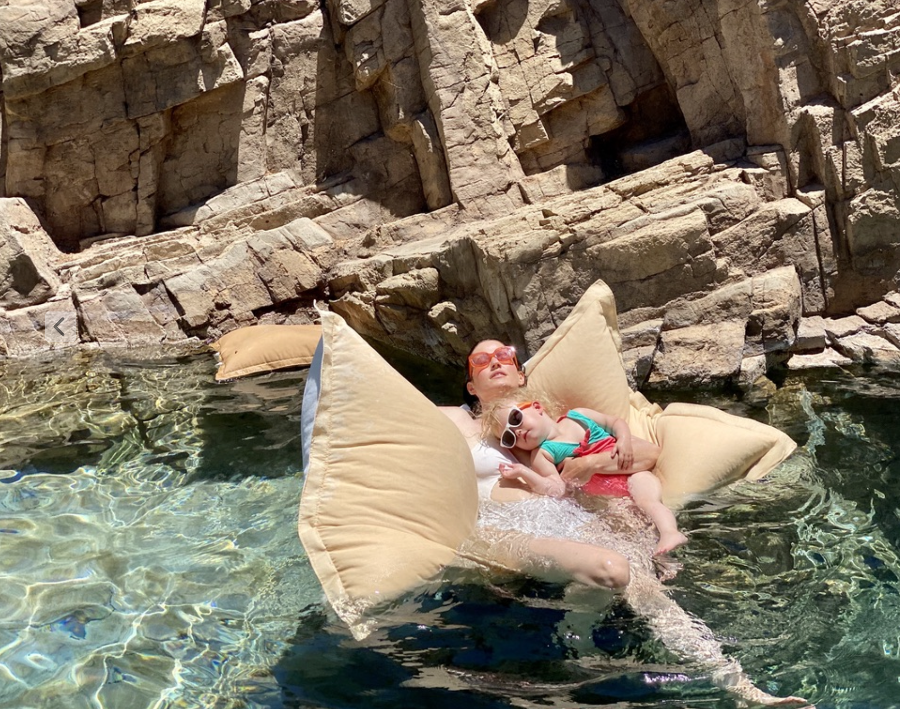 Mother and daughter floating in natural pool